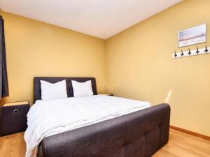 VerlaineにあるCharming Holiday Home In Durbuy with Gardenのベッドルーム1室(黄色い壁の大きな白いベッド1台付)