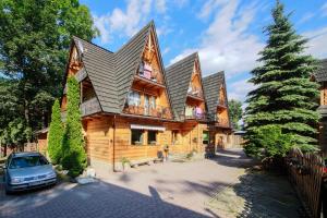a log cabin with a car parked in front of it at Willa Belmont in Zakopane