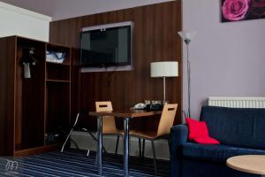 a living room filled with furniture and a tv at Piries Hotel in Edinburgh