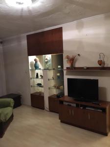 a living room with a flat screen tv and a entertainment center at Tocc Apartman in Gyál