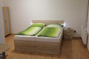 ブルノにあるApartmán 2のベッド1台(緑の枕2つ付)