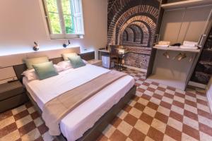 a bedroom with a large bed and a brick wall at Giardino Labruto in Messina