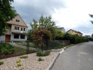 a house with a fence on the side of a street at Apartament Malwina in Polanica-Zdrój