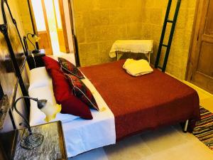 een slaapkamer met een bed met rode kussens erop bij Borgo in corte in Martano
