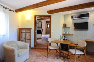 a living room with a table and chairs and a bedroom at Lodge de Charme A Cheda in Bonifacio