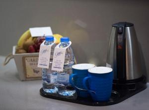 a coffee maker with two cups and bottles of water at Gems Hotel in Beirut