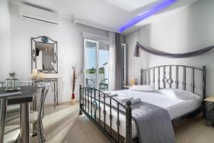 a bedroom with a bed and a desk and a mirror at A Ponte Studios & Apartments in Sykia Chalkidikis