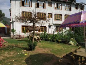 a building with a tree in front of it at Valley holidays in Srinagar