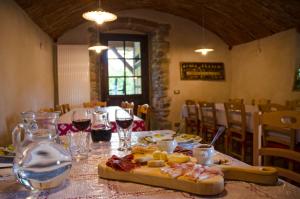 a table with a plate of food and glasses of wine at Agriturismo il posto delle fragole in San Giovanni Bianco