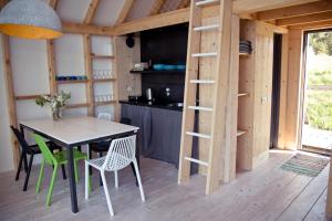 a kitchen and dining room of a tiny house at Peldmaja in Pāvilosta
