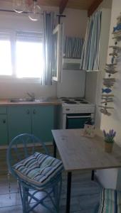 una cucina con tavolo, sedia e piano cottura di Fani House a Kallithea