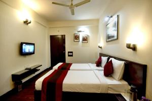 a hotel room with a bed and a television at Crystal Inn in Agra