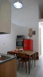 een keuken met een tafel en een rode koelkast bij Cardìlle Apartment in Monopoli