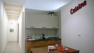 een keuken met witte kasten en een houten tafel bij Cardìlle Apartment in Monopoli