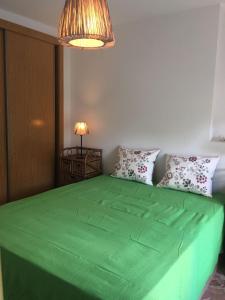 ベニドルムにあるApartamento Capucineのランプ付きの客室内の大型緑色ベッド
