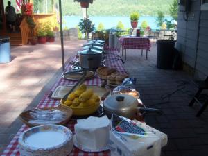 a picnic table with food on a red and white table cloth at Cobblescote on the Lake in Cooperstown