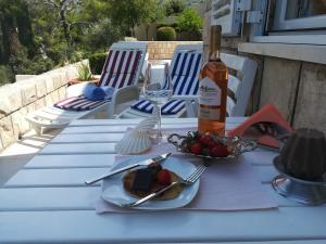 a table with a plate of food and a bottle of wine at Soba Mirus in Cavtat