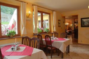 un restaurante con 2 mesas con manteles rojos y blancos en Hotel Diament, en Szklarska Poręba