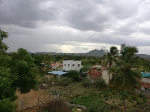 a view of a village with mountains in the background at Selvalakshmi Restaurant and Lodge in Tiruvannāmalai