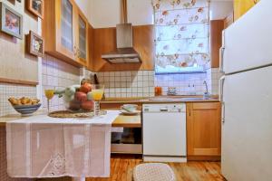 a kitchen with a white refrigerator and a table with fruit on it at Bonagrazia in Corfu Town +11 photos