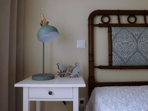 佩納菲耶爾的住宿－Casa Máximo，床头的白色桌子上的一盏灯
