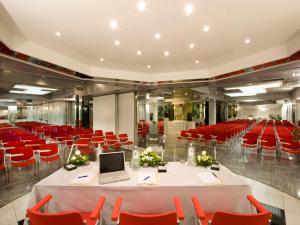 a conference room with red chairs and a table with a laptop at Hotel Savoy in Pesaro +72 photos