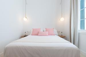 a bedroom with a bed with pink pillows on it at LLONGA'S 11th in Ciutadella