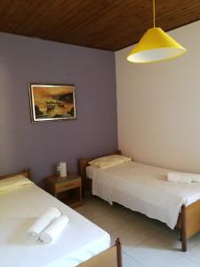 ザンブローネにあるVilla Collemareのベッド2台と黄色のライトが備わる客室です。