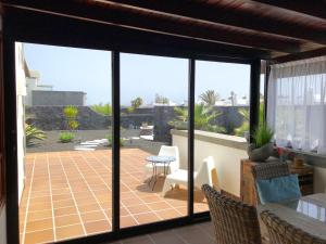 einen Wintergarten mit Glasschiebetüren und einer Terrasse in der Unterkunft Villa Mici in Playa Blanca