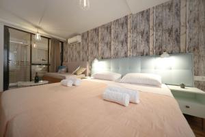 1 dormitorio con 1 cama grande y toallas. en Central Apartments Integrated Hotel en Zadar
