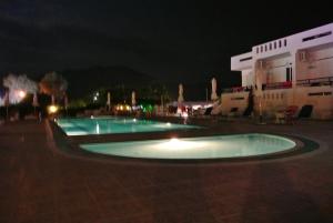 a couple of pools in a courtyard at night at Kokalakis Hotel in Kefalos