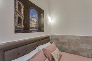 un letto con cuscini e una foto di una cattedrale di Navona Charme Suite a Roma