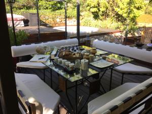 een tafel en stoelen op een balkon met eten erop bij Bulle d'amour in Montauroux
