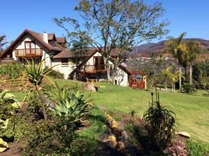 a house on a hill with a green yard at Fish Eagle Lodge in Knysna