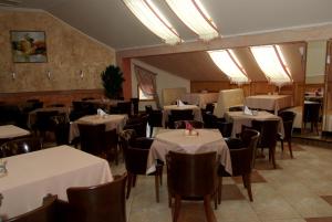 a dining room with tables and chairs with white table cloth at Olimp Hotel in Svetlogorsk