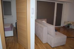 two views of a living room with a white couch at Bisera in Skopje