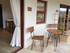 Zimmer mit 2 Stühlen, einem Tisch und einem Fenster in der Unterkunft Fish Eagle Lodge in Knysna