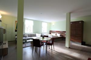 ein Wohnzimmer mit einem Sofa, einem Tisch und Stühlen in der Unterkunft Villa 39 Apartment Hotel in Bad Liebenstein