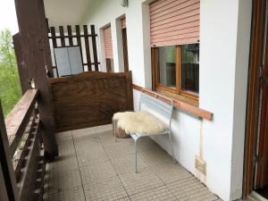 a white chair sitting on a porch with a window at Relax holiday in Sestriere