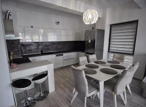 a kitchen with a table and chairs in a kitchen at Apartament Diana in Târgu-Mureş