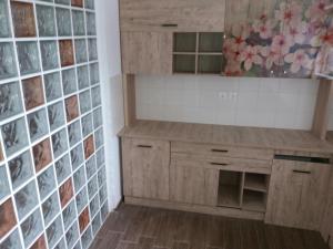 a kitchen with wooden cabinets and a tile wall at Apartament lux Albert in Olimp +22 photos