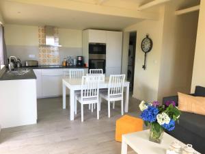 a kitchen and a living room with a table and chairs at Casa do Almance in São João