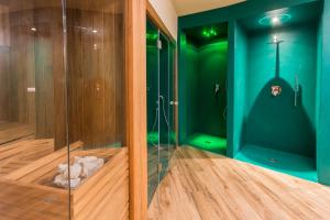 a green bathroom with a shower with a glass wall at Mediterraneo Emotional Hotel & Spa in Santa Margherita Ligure