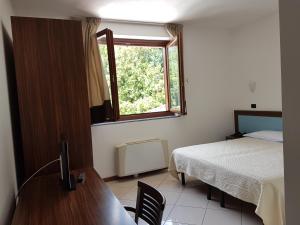 Postel nebo postele na pokoji v ubytování Hotel & Residence La Sibilla Cusiana