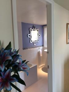 a bathroom with purple walls and a mirror on the wall at Bretton Cottage in Eyam