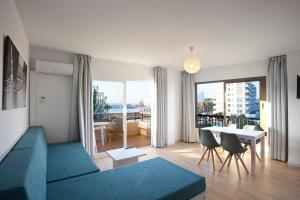 a living room with a blue couch and a table at BJ Playamar Hotel & Apartamentos in S'Illot