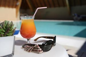 a drink and a pair of sunglasses on a table at Best Western Le Pont d'Or in Figeac