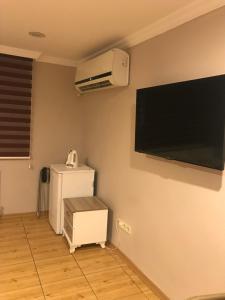 a room with a refrigerator and a flat screen tv at Altınboynuz Family Hotel in Istanbul