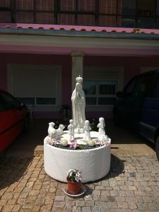 una fuente con pájaros y flores frente a un edificio en Joaquim do Norte, en Podence