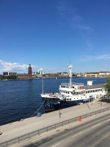um grande barco ancorado na água ao lado de uma estrada em Gustaf af Klint em Estocolmo